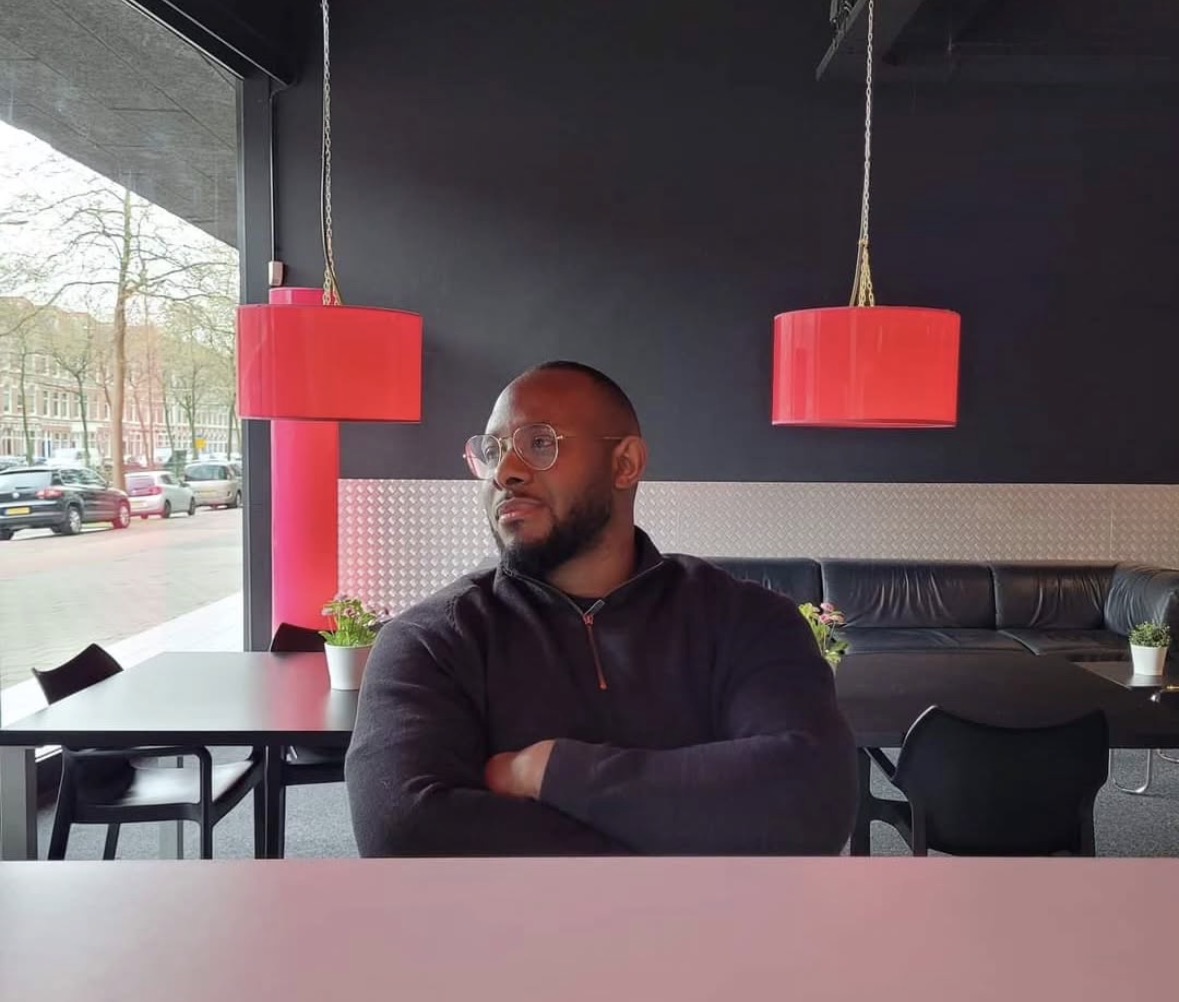 The founder of QualityMuscles, seated with his arms folded
